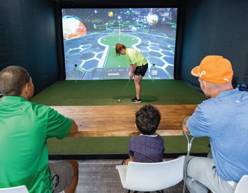 family playing mini golf on simulator